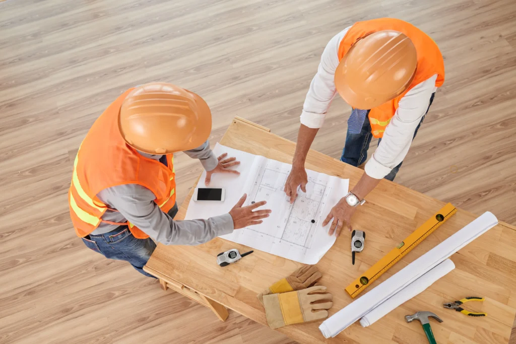 hands engineer worker holding yellow safety helmet with building site background and residential construction pune